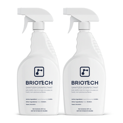 Two white bottles of Sanitizer Disinfectant with spray nozzles are shown. The labels highlight that this disinfecting spray kills bacteria, viruses, and SARS-CoV-2 in two minutes on hard, non-porous surfaces.