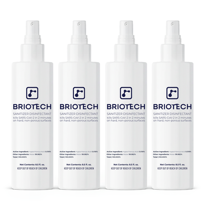 Four white bottles of Sanitizer Disinfectant with spray tops are lined up, each highlighting their effectiveness against bacteria and viruses on non-porous surfaces.
