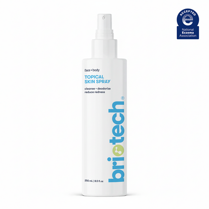 A white spray bottle labeled Topical Skin Spray for face and body, featuring blue and green text. This soothing spray cleanses, deodorizes, reduces redness, calms irritation, and comes in a 250 ml (8.5 fl oz) bottle.