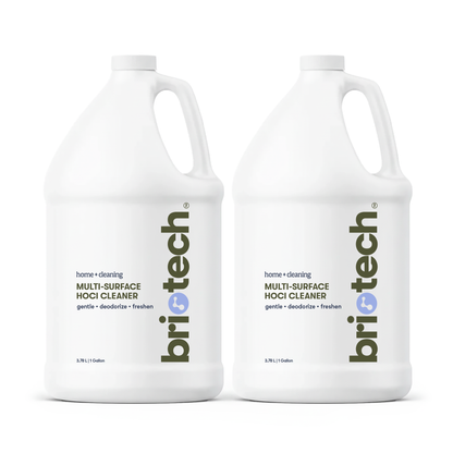Two white gallon bottles labeled Multi-Surface HOCl Cleaner, featuring minimalist text and a blue logo, stand side by side against a white background. This cleaner is ideal for cleaning and deodorizing your home, and is safe for use around kids and pets.