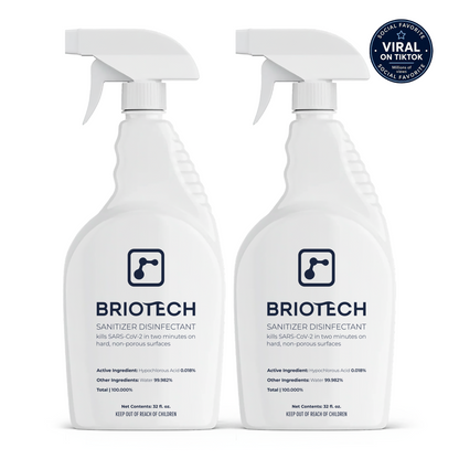 Two white spray bottles of Sanitizer Disinfectant stand side by side. A blue circular badge in the upper right corner reads Viral on TikTok. The label emphasizes its effectiveness as a disinfecting spray against bacteria and viruses on hard, non-porous surfaces.