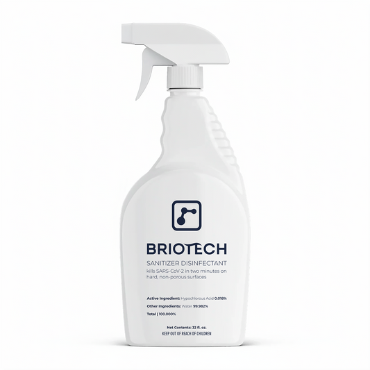 A white spray bottle labeled Sanitizer Disinfectant, a disinfecting spray for non-porous surfaces, displays text about killing SARS-CoV-2 in two minutes set against a plain white background.