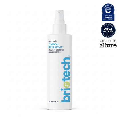 A white spray bottle labeled Topical Skin Spray for face and body. The label features logos from the National Eczema Association, Allure, and “Viral on TikTok.” Text highlights its cleansing and deodorizing properties, reduces redness, and describes a soothing skin spray formula that calms irritation while helping to reduce blemishes.